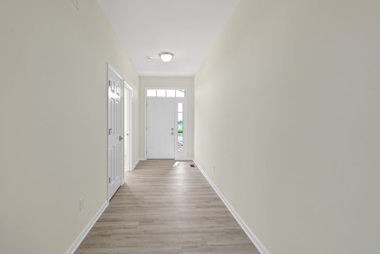 Entryway foyer in the Gerstad Builders Truman floor plan featuring a long hallway layout with front door and interior access points.