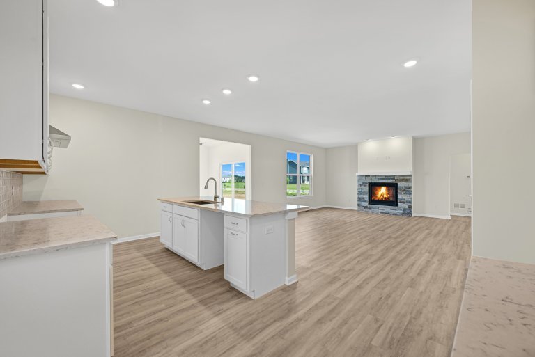 Open-concept kitchen and living area in the Gerstad Builders Truman floor plan featuring a central island and spacious connected living space.