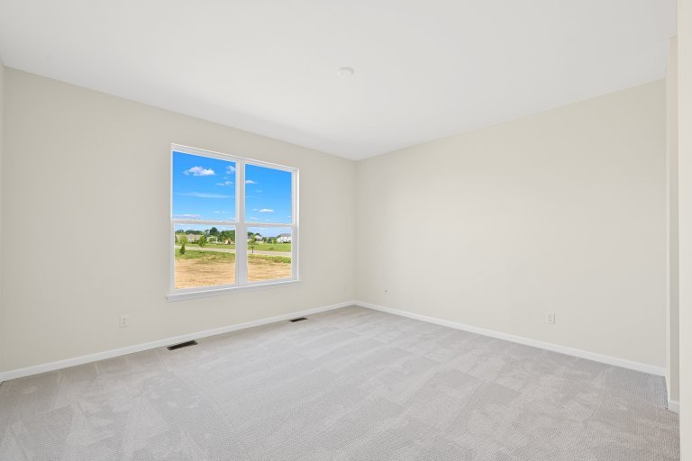 Secondary bedroom in the Gerstad Builders Truman new construction home featuring an open layout and bright natural light.