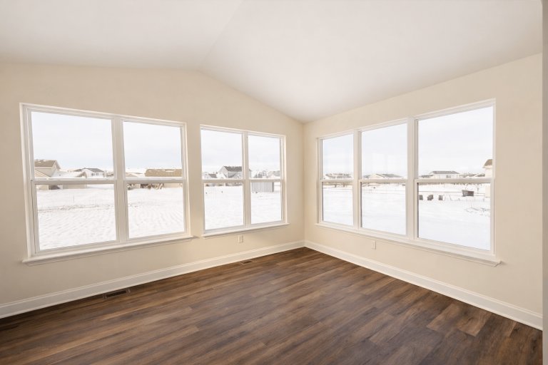 Bright sunroom in the Jefferson model featuring expansive windows, vaulted ceiling, and panoramic views that highlight the room’s open and inviting design.