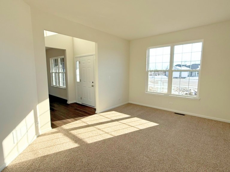 Front flex room in Georgian floor plan featuring large windows, natural light, and versatile space for office, sitting room, or den in a new construction home.