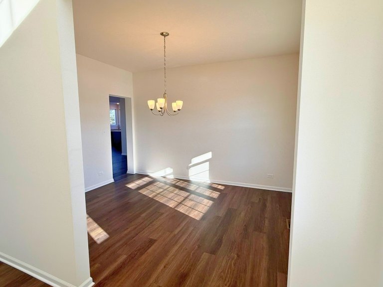 Dedicated dining room in new construction home showcasing open layout, neutral walls, and stylish overhead lighting.