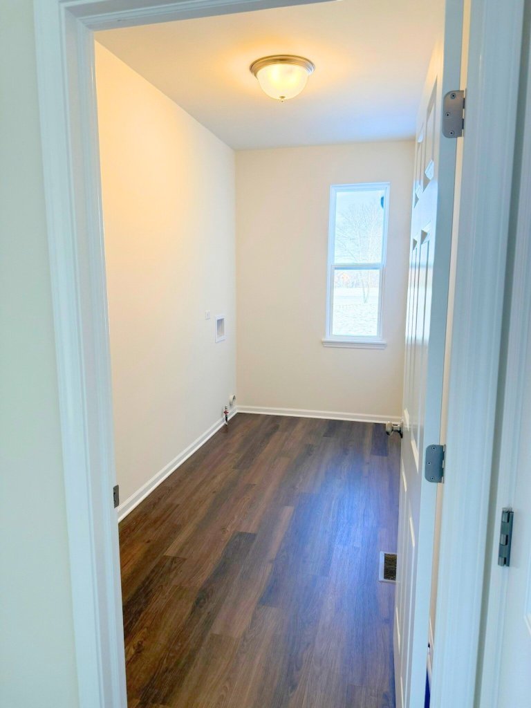 Laundry room in Georgian floor plan home featuring natural light window and dedicated washer and dryer hookups in a new construction house.