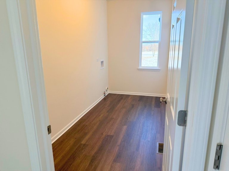 Laundry room in Georgian floor plan home featuring natural light window and dedicated washer and dryer hookups in a new construction house.